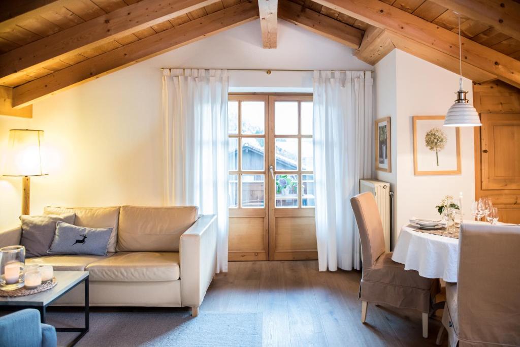 uma sala de estar com um sofá e uma mesa em Haus Lesch - Stilvolle Appartements mit tollem Bergblick in Kreuth am Tegernsee em Kreuth