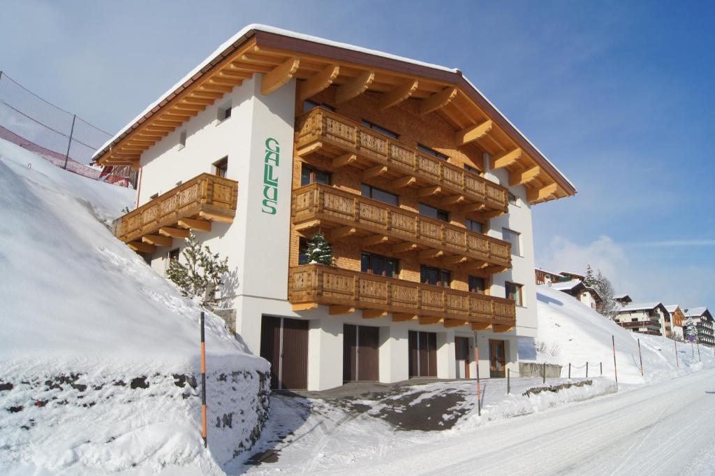 um edifício na neve com neve à sua volta em Pension Gallus em Lech am Arlberg