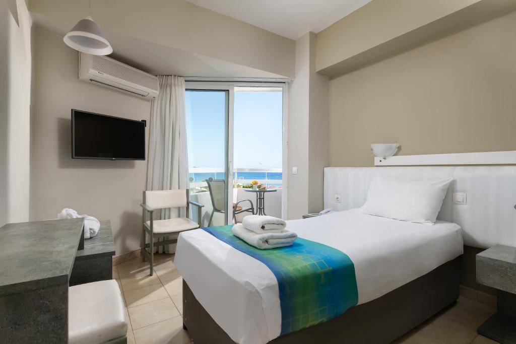 a bedroom with a bed with a view of the ocean at Lito Hotel in Ixia
