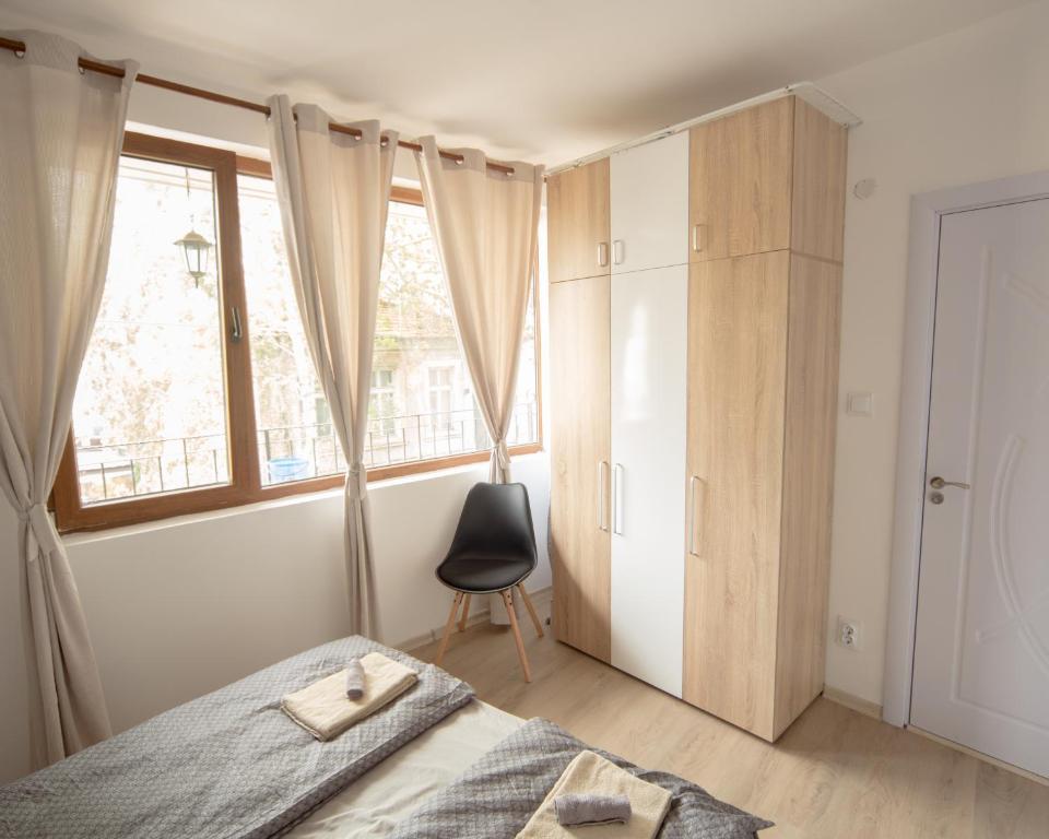 a bedroom with a bed and a window and a chair at Aleks Top Center 2- Free parking in Burgas City