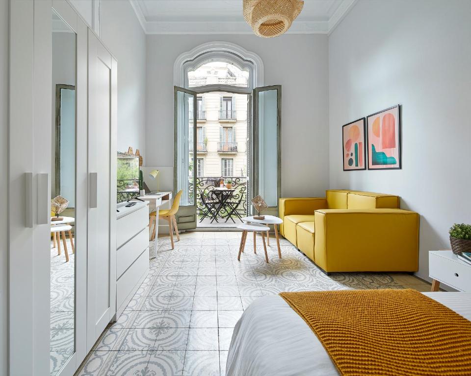 a bedroom with a bed and a yellow couch at GIRONA in Barcelona