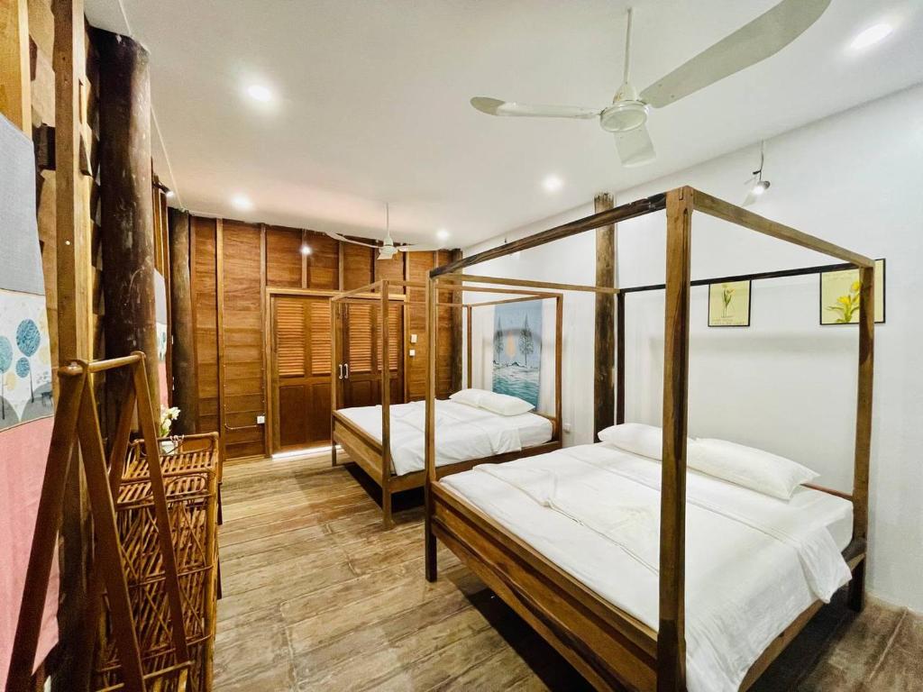 a bedroom with two beds and a ceiling at HOLY VILLA 4rooms, 5beds, 6baths, 1KCH, 1LR riverside private villa in Kampot