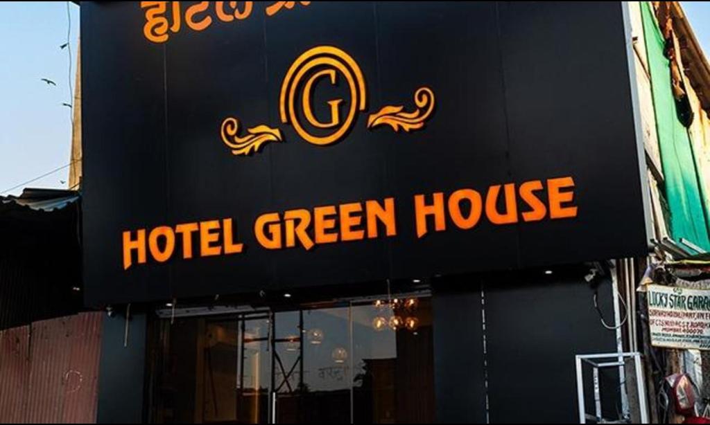 een hotelbord met groene huizen aan de zijkant van een gebouw bij FabHotel Green House in Mumbai