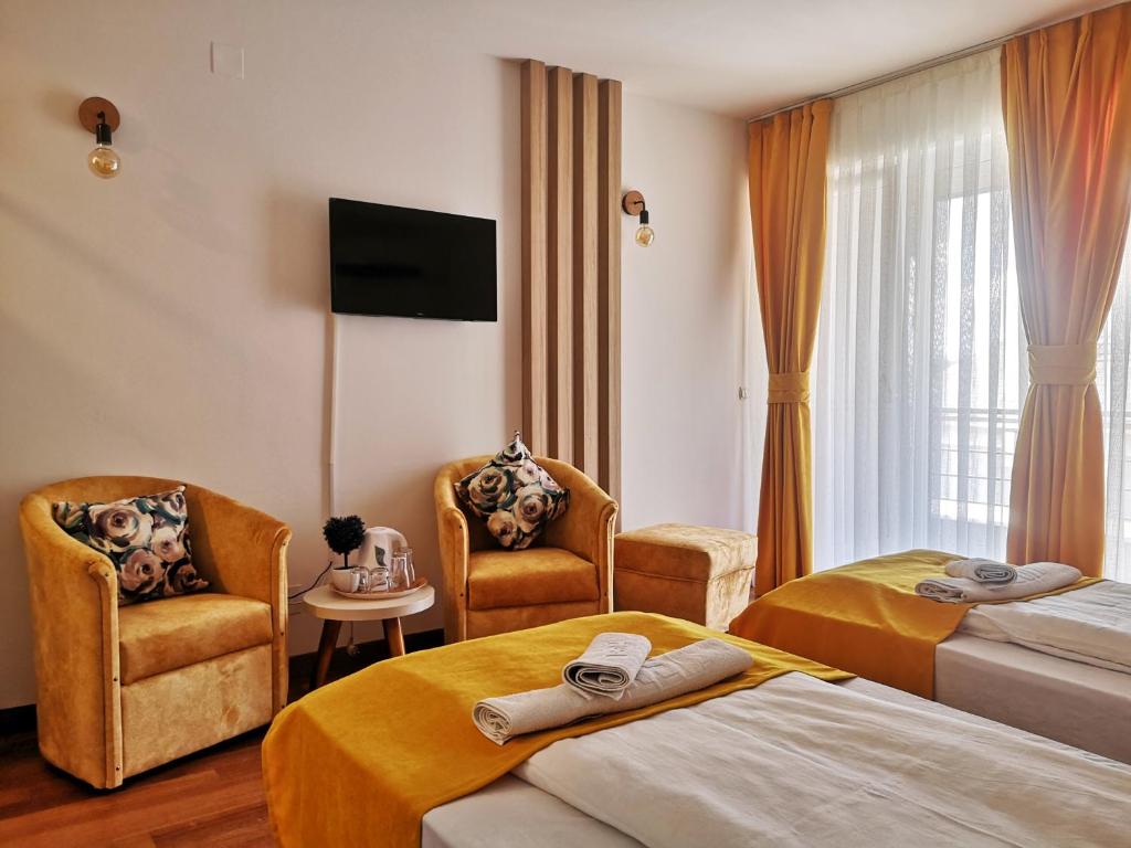 a hotel room with two beds and two chairs at Villa Pestani in Peštani