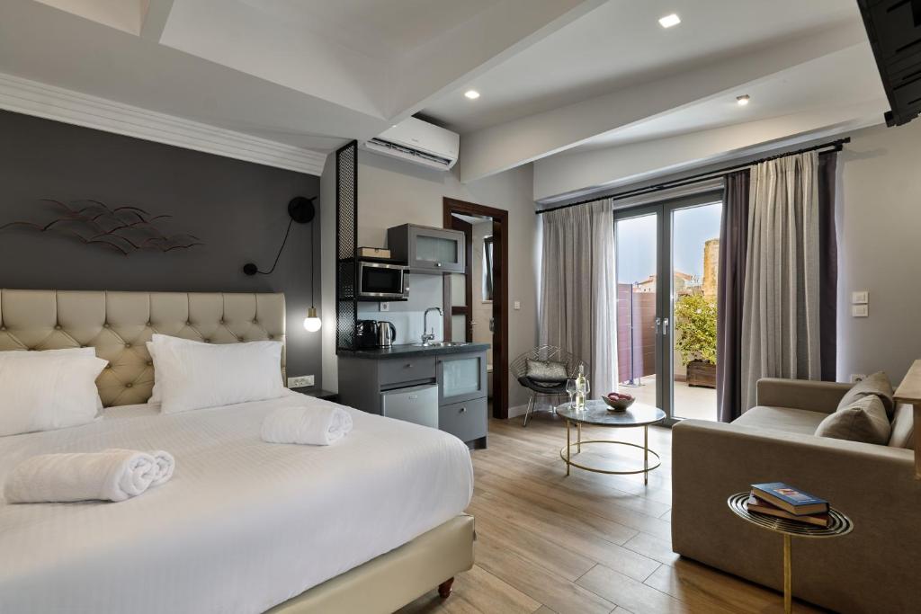 a bedroom with a large bed and a living room at Nival Luxury Suites in Chania