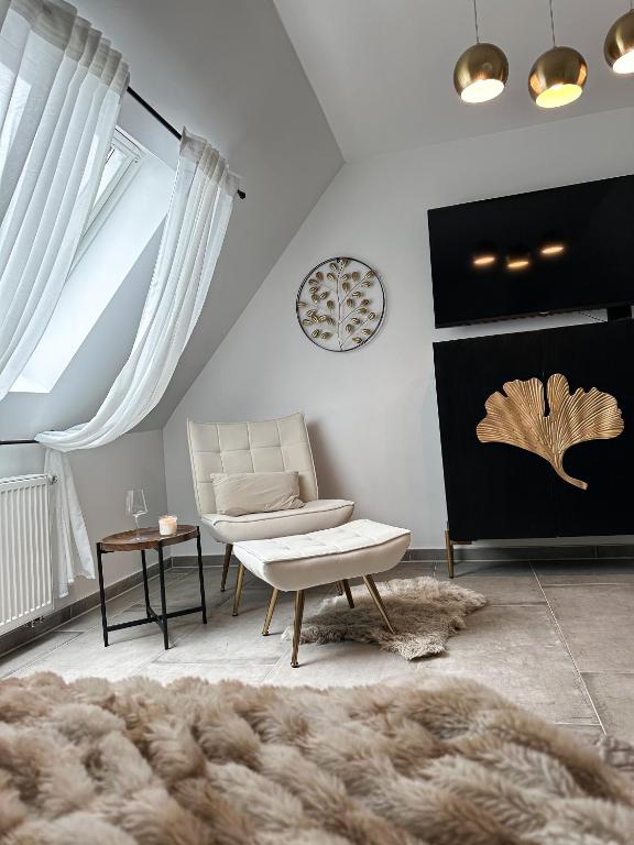 ein Wohnzimmer mit einem Sofa und einem Stuhl in der Unterkunft Deluxe Apartment in Duisburg