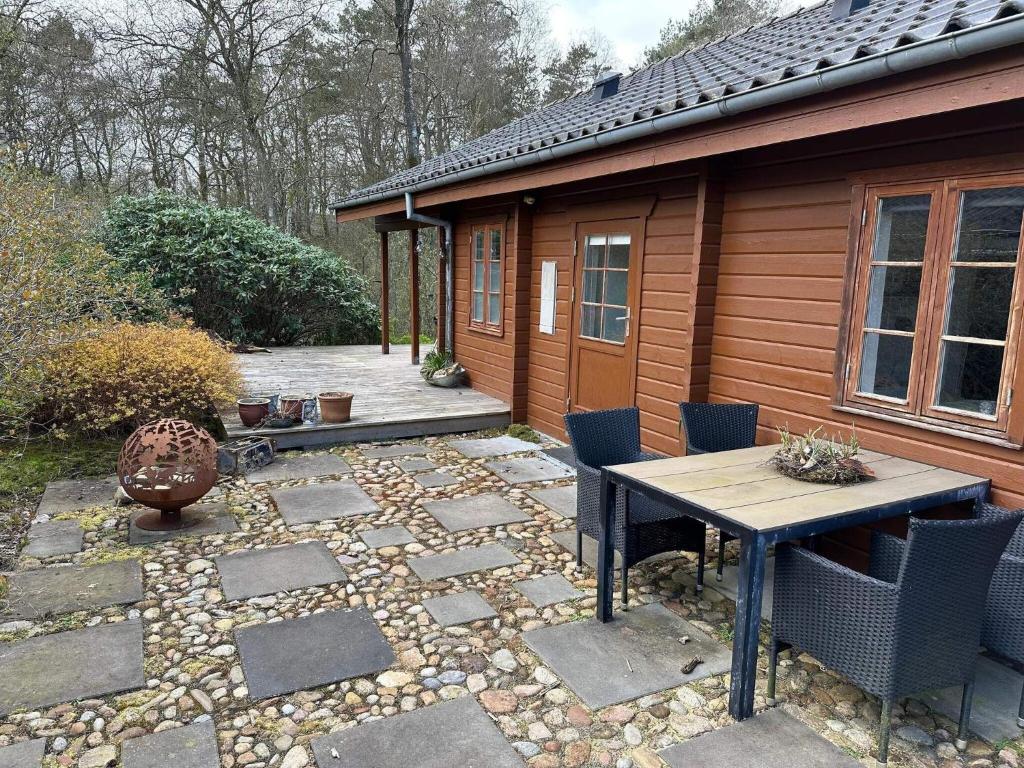 a patio with a table and chairs next to a cabin at Holiday home Kibæk in Kibæk