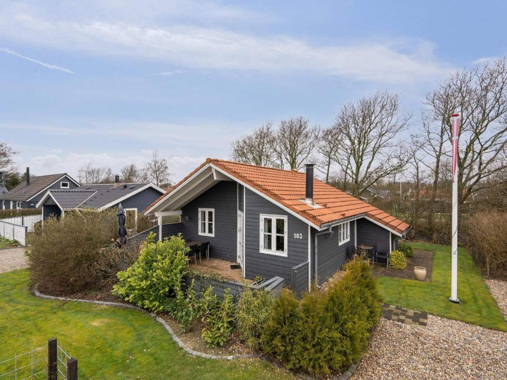 a small house with an orange roof on a yard at Holiday home Hemmet VI in Hemmet