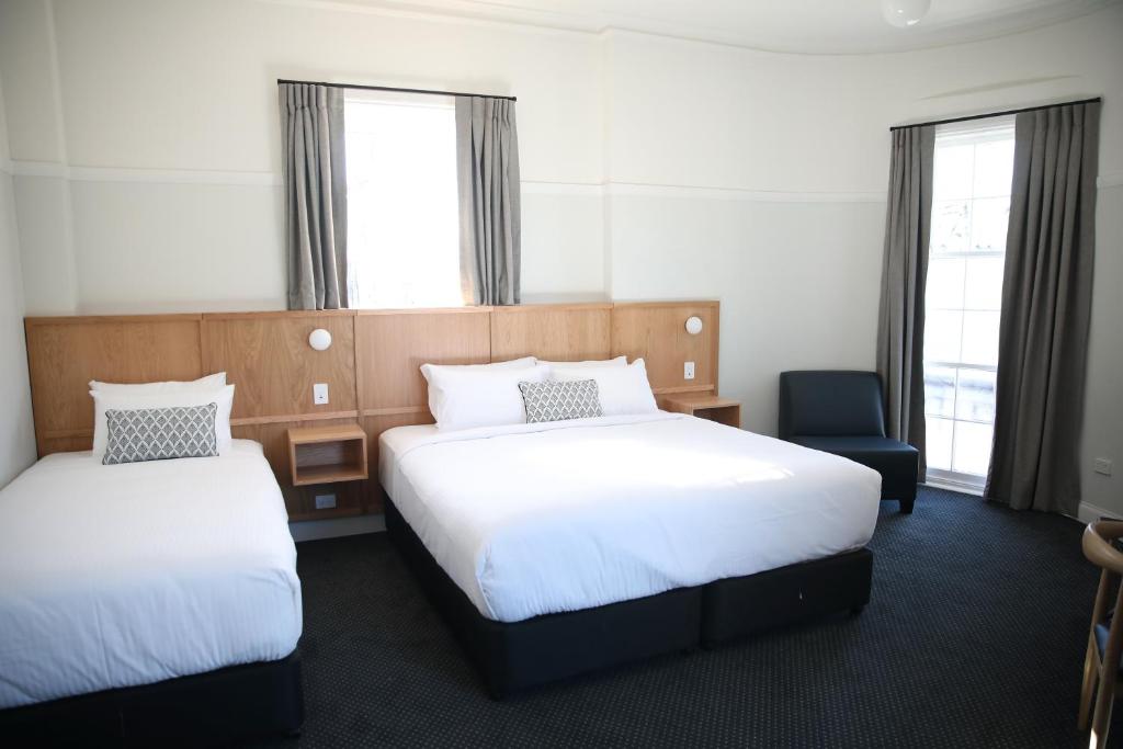 a hotel room with two beds and a chair at Mortdale Hotel in Mortdale