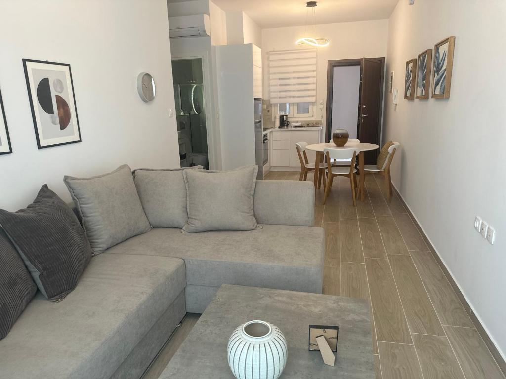 - un salon avec un canapé et une table dans l'établissement Iliana's apartment 2, à Karditsa