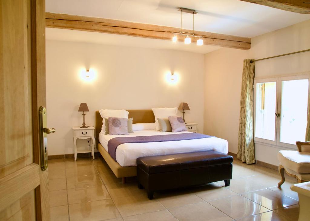 Schlafzimmer mit einem Kingsize-Bett und einem Fenster in der Unterkunft A Propos - Chambres d'Hôtes in Orange