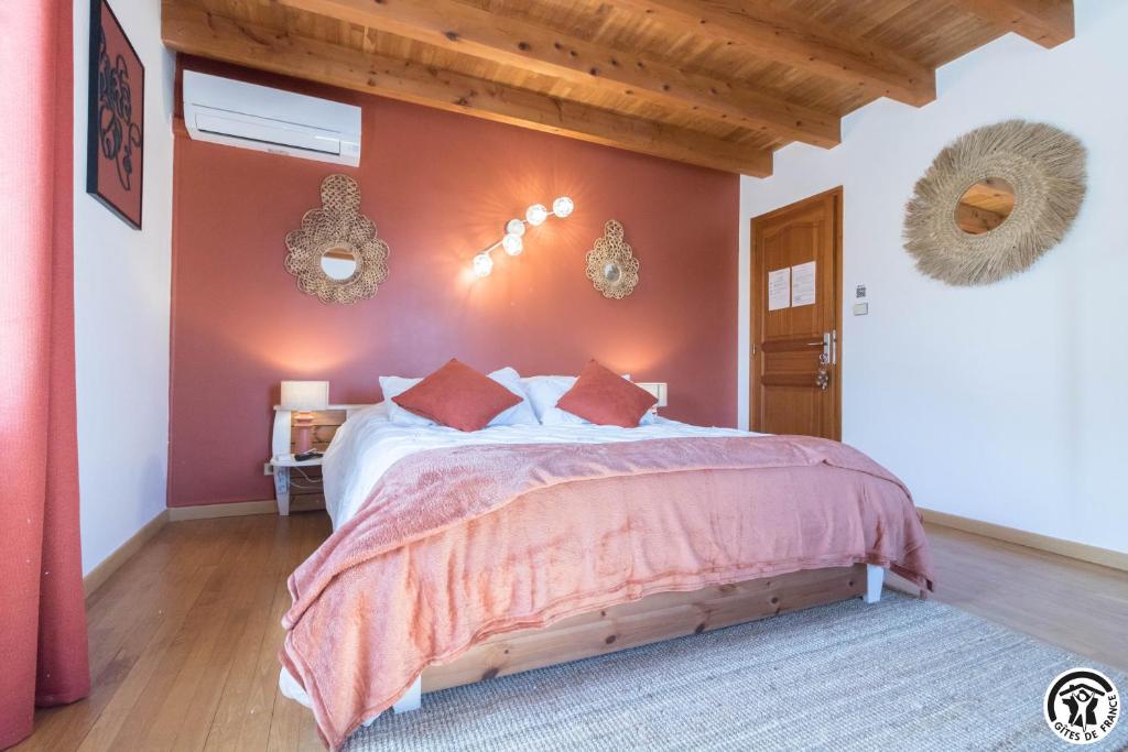 La maison d'Hôtes Du Moulin في Lagardelle-sur-Lèze: غرفة نوم بسرير كبير وبجدران حمراء