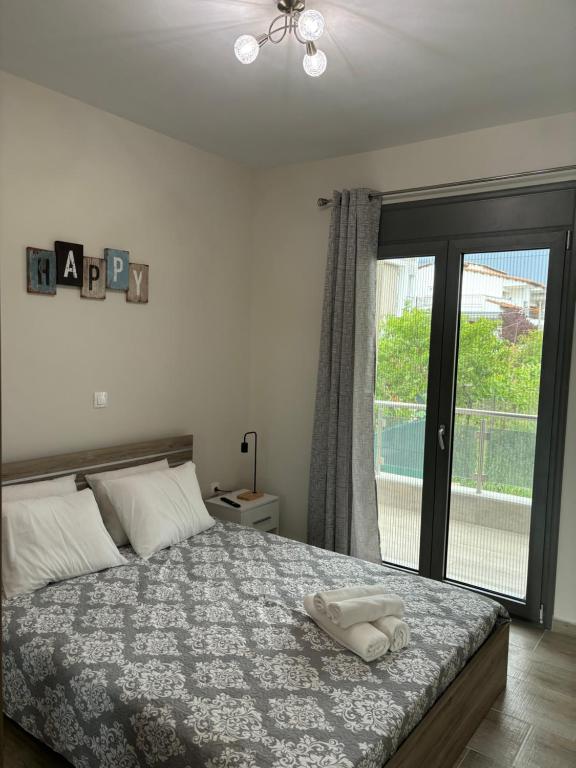 a bedroom with a bed and a large window at Anna-Maria Appartement in Kalives Poligirou