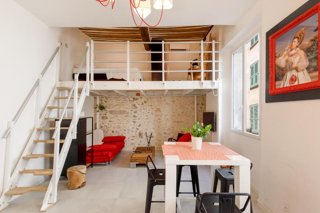 un loft avec un escalier et un canapé rouge dans l'établissement Incredible loft in Vieil Antibes with AC, à Antibes