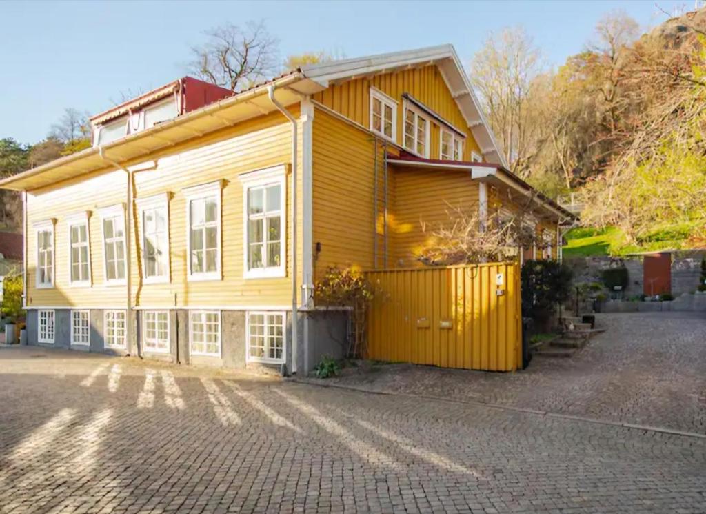 a yellow house with a gate in front of it at Outstanding apartment close to Gothenburg in Kungälv