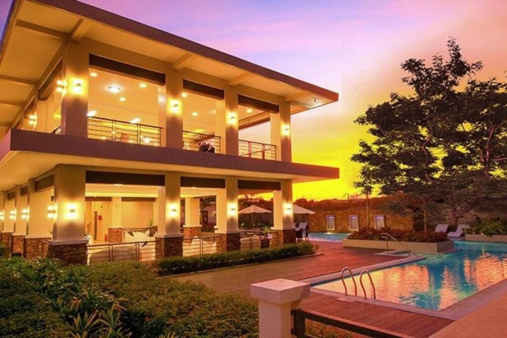 uma casa grande com uma piscina em frente em Two Bedroom Condo Unit at 8 Spatial Davao em Davao