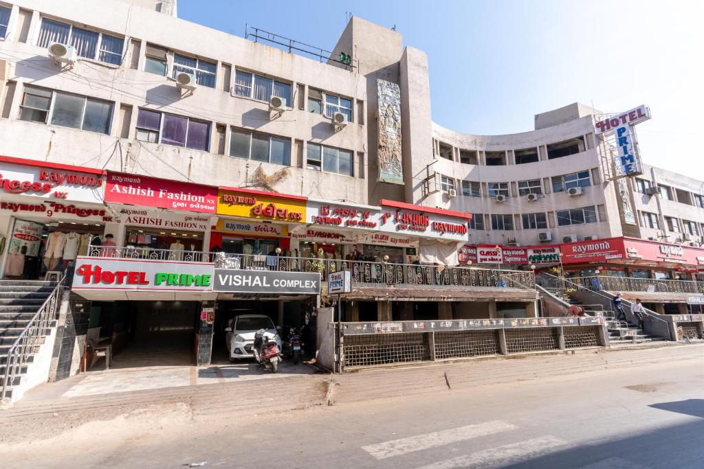 uma rua da cidade com um edifício com lojas em Hotel Prime em Ahmedabad