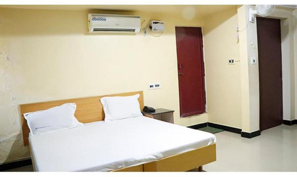Habitación hospitalaria con cama y calentador en la pared en FabExpress Sivabhagya Annex, en Madurai