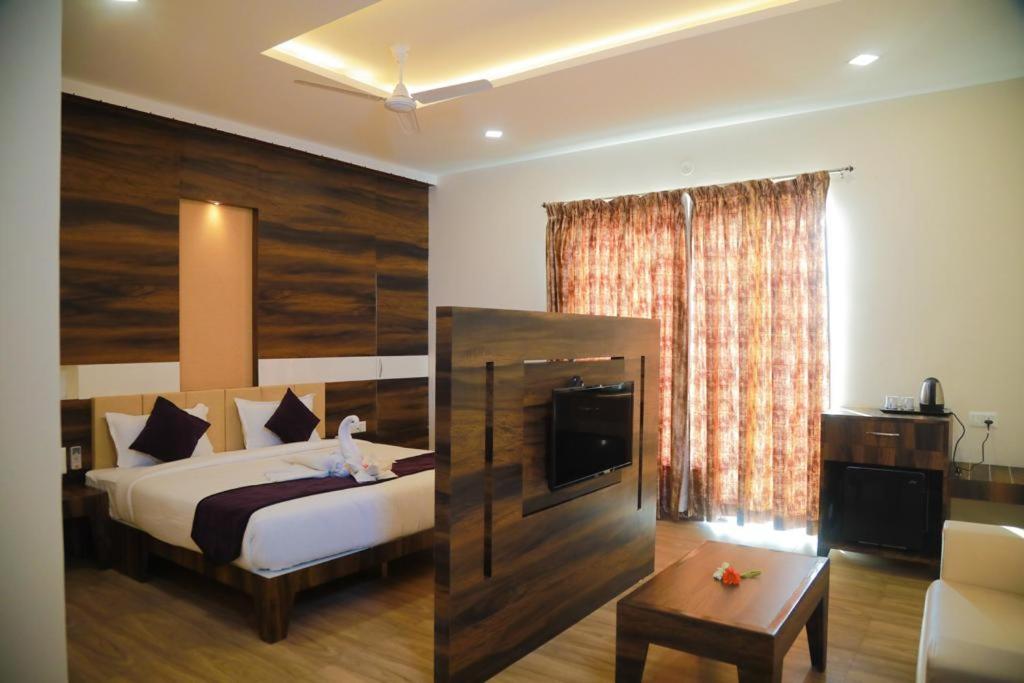 a bedroom with a bed and a couch and a table at Hotel Milan Bijapur in Bijāpur