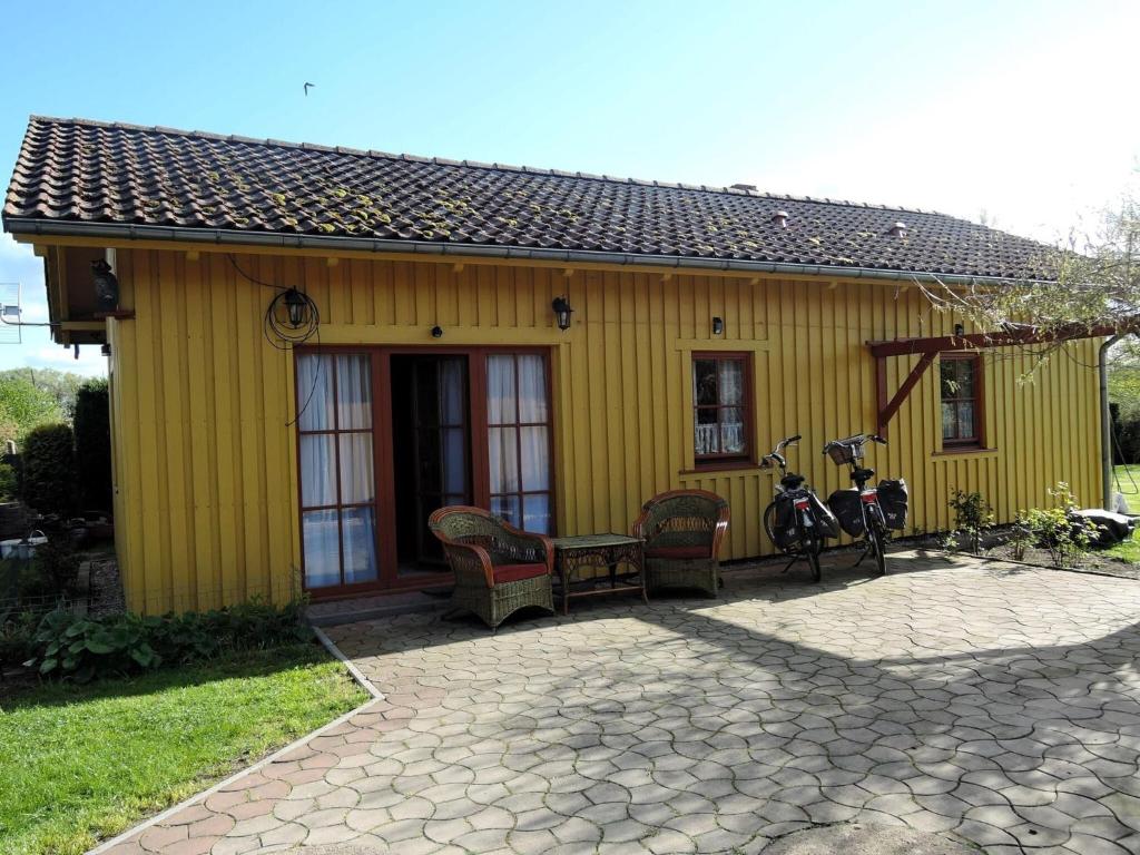 una casa amarilla con dos bicicletas estacionadas fuera de ella en Comfortable holiday home, Stepnica en Stepnica