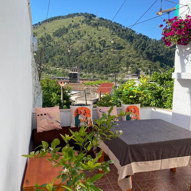 a balcony with a table and a mountain in the background at Ziu Guest House in Berat