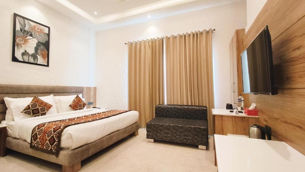 une chambre d'hôtel avec un lit et une chaise dans l'établissement Blessings Hotel, à Amritsar