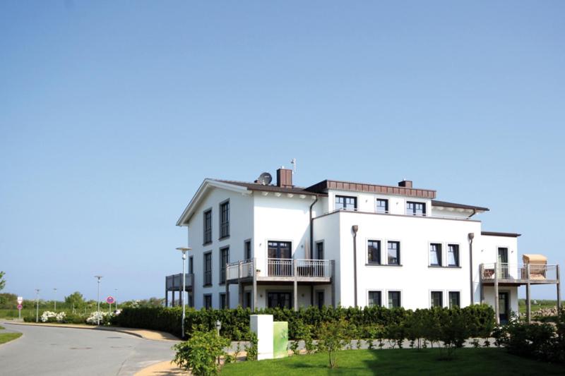 a large white building on the side of a street at Strandresidenz in Börgerende-Rethwisch