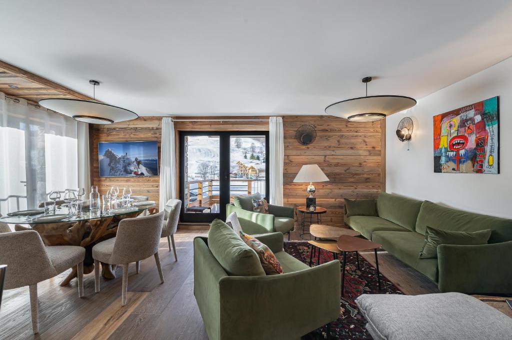 uma sala de estar com mobiliário verde e uma mesa em Appartement Sifflote - LES CHALETS COVAREL em La Daille
