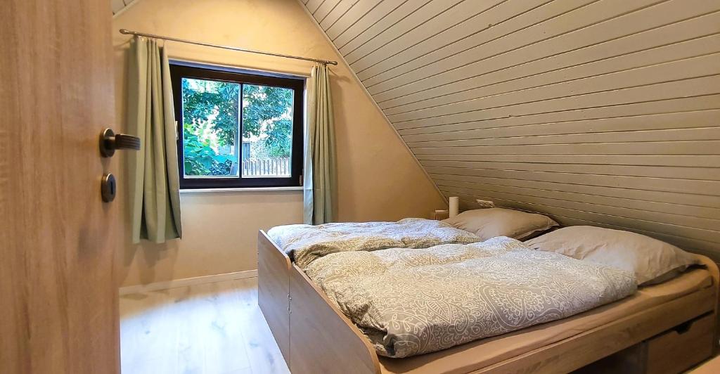 Bett in einem Zimmer mit Fenster in der Unterkunft Chata pri 7 jazerách s vyvýšenou terasou in Štiavnické Bane