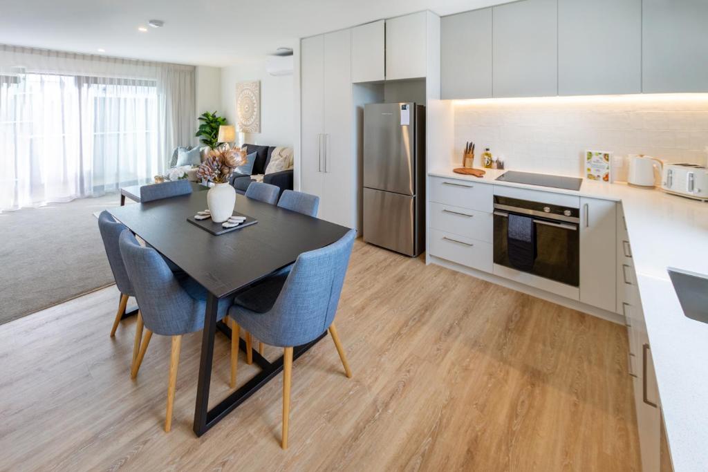 Relaxing City Hideaway - 2 Bed in Christchurch CBD في كرايستشيرش: مطبخ وغرفة طعام مع طاولة وكراسي