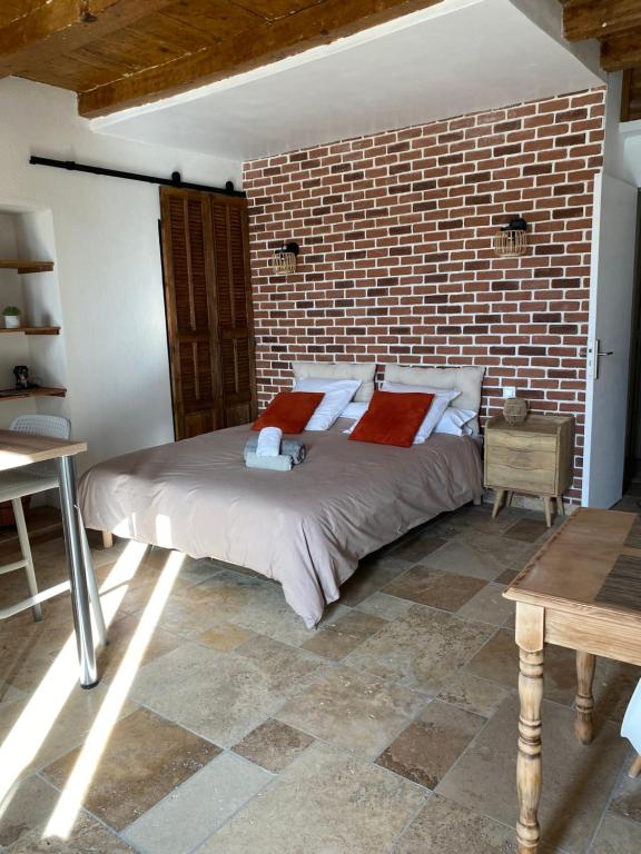 a bedroom with a brick wall and a bed at Très beau studio avec terrasse in Zonza