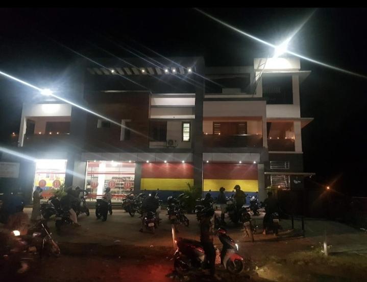 un grupo de motocicletas estacionadas frente a un edificio por la noche en Unnimaya, en Kattakkada