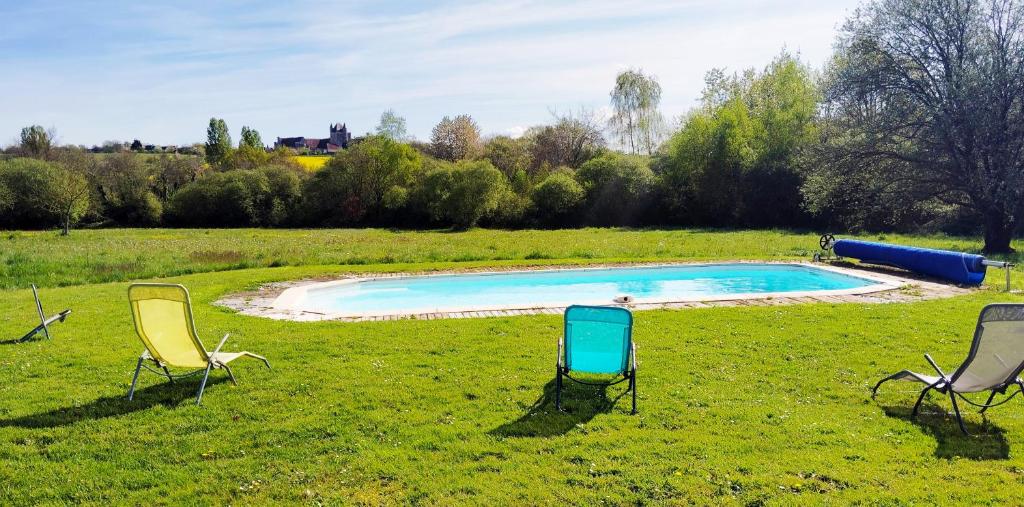 trzy krzesła i basen na polu w obiekcie Domaine de Matounet w mieście Bridoré