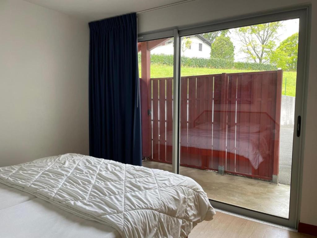 a bedroom with a bed and a sliding glass door at MEHATCHE Piscine Vue Montagnes in Souraïde