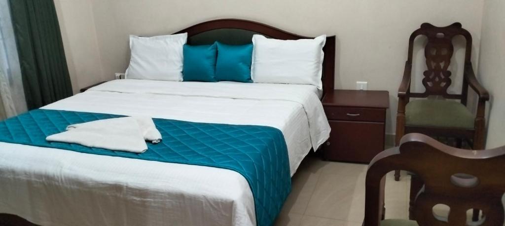 Elim Homestay Fort Kochi في كوتشي: غرفة نوم بسرير كبير مع بطانية زرقاء وبيضاء