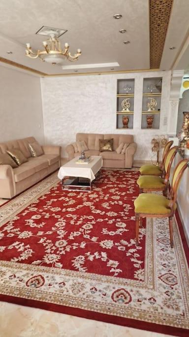 uma sala de estar com um sofá e um tapete vermelho em Spacieux appartement au centre-ville de Tanger em Tânger