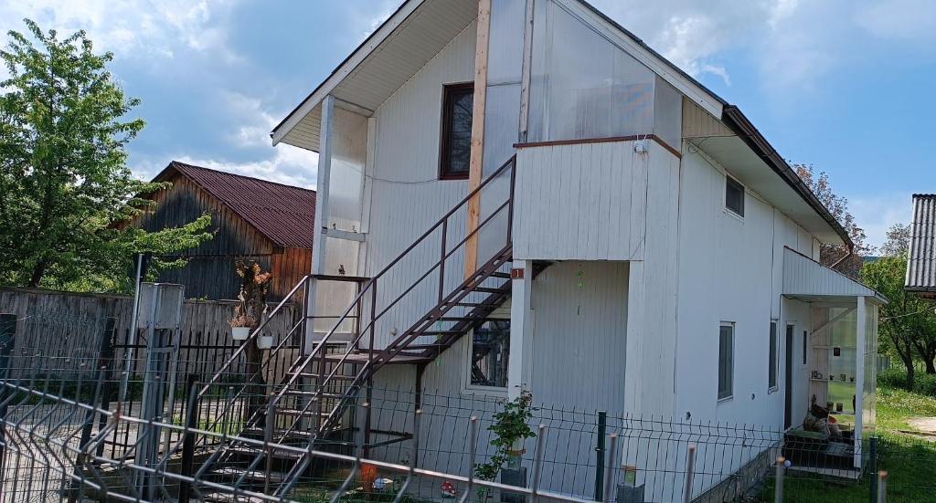 een wit huis met trappen aan de zijkant bij Casa de vacanta Balan in Prundul Bîrgăului