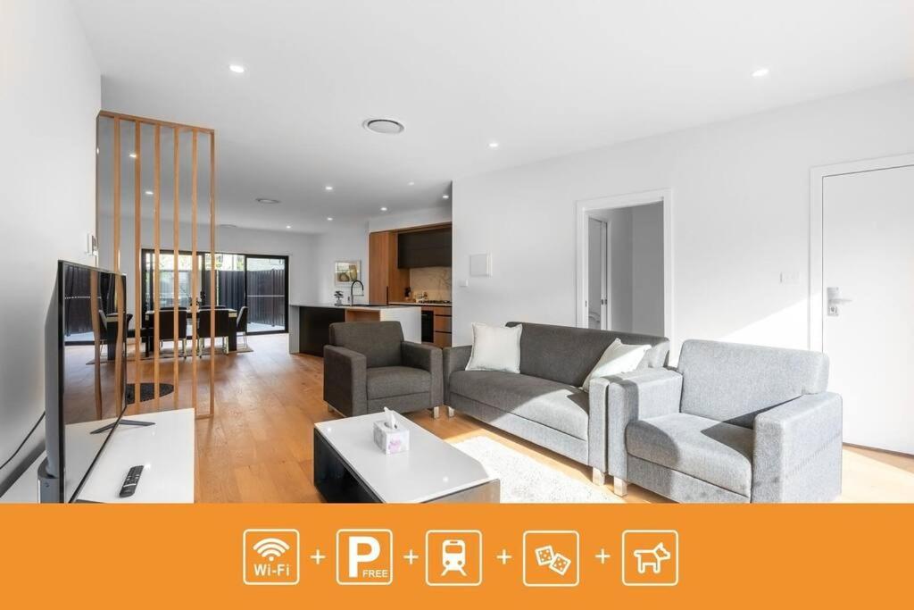 ein Wohnzimmer mit 2 Sofas und einem TV in der Unterkunft O‘Connor 3 bedroom Townhouse in Canberra in Canberra