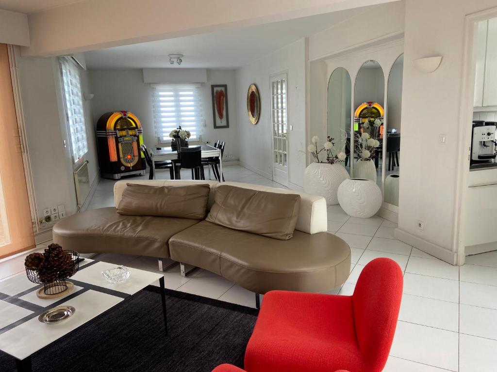 - un salon avec un canapé et un fauteuil rouge dans l'établissement La Rose des vents, à La Rochelle