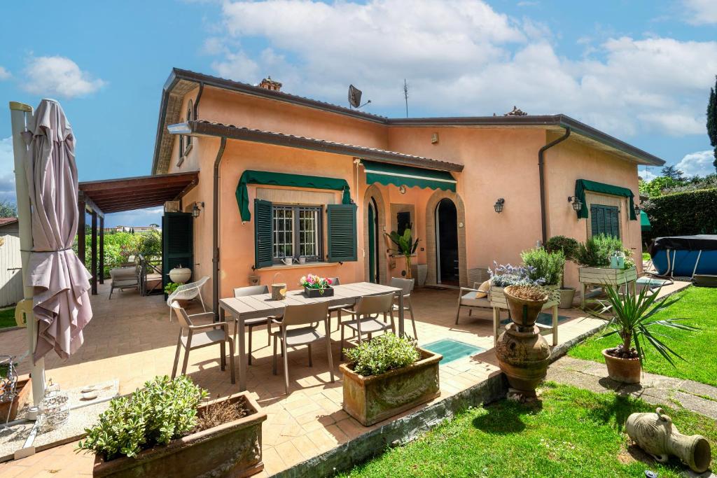ein Haus mit einer Terrasse mit einem Tisch und Stühlen in der Unterkunft Residenza Menta e Rosmarino in Perugia