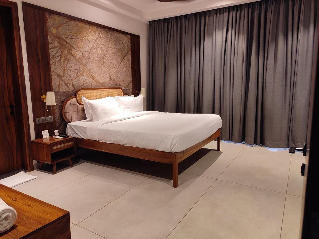 a bedroom with a bed with white sheets and white pillows at Manas Lifestyle Villas, Igatpuri in Igatpuri