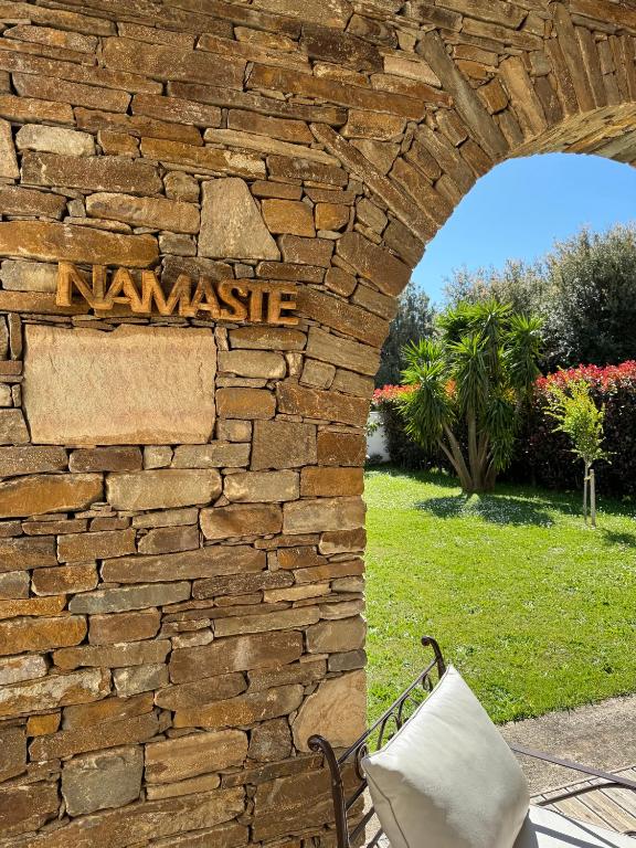 a stone wall with a sign that reads namaste at Les 5 Arches in Sisco