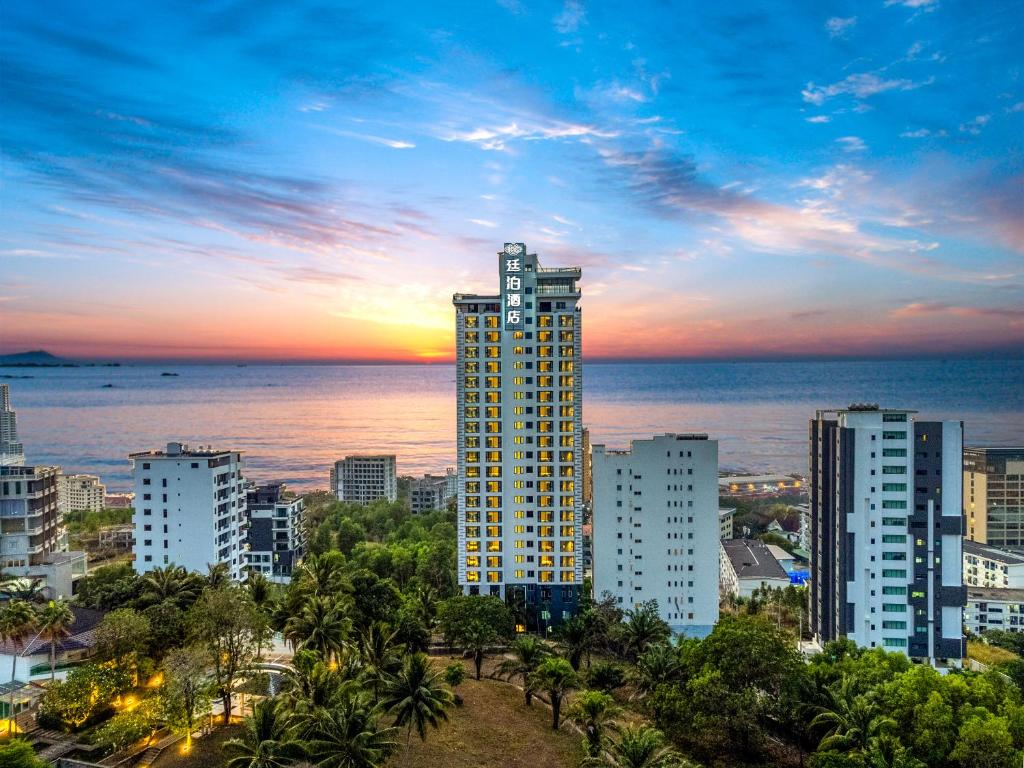 een skyline van de stad met een hoog gebouw en de oceaan bij Ting Bo Hotel Sihanoukville Autonomous Port Branch 廷泊酒店西哈努克高龙岛码头店 in Sihanoukville