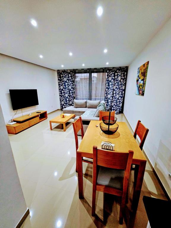 普拉亚Kingfisher 2A and Seagull 4A Plateau Apartments on Rua Pedonal Praia Cape Verde的带桌椅和电视的客厅