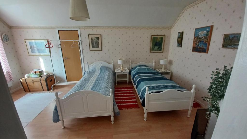 a bedroom with two beds and a table and a desk at Förvaltarbostaden in Åtvidaberg