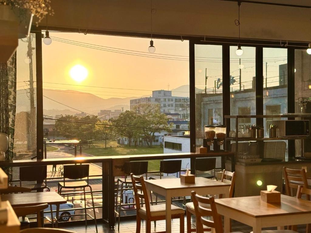 un restaurante con mesas y sillas y vistas a la ciudad en Gyeongju BonghwangMansion en Gyeongju