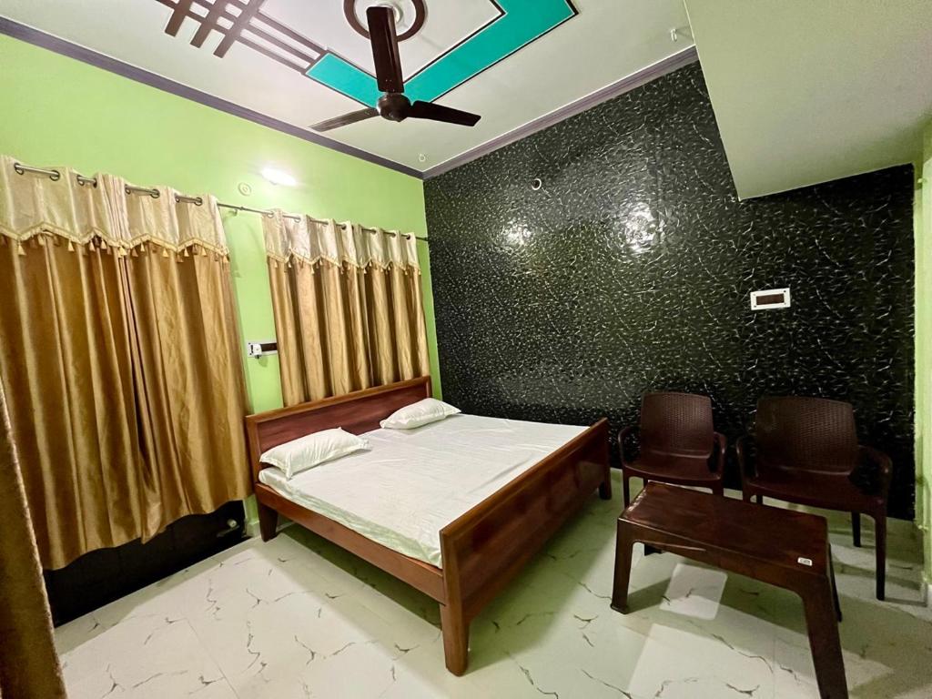 1 dormitorio con 1 cama y 2 sillas en Sainik Homestay, Ayodhya en Ayodhya