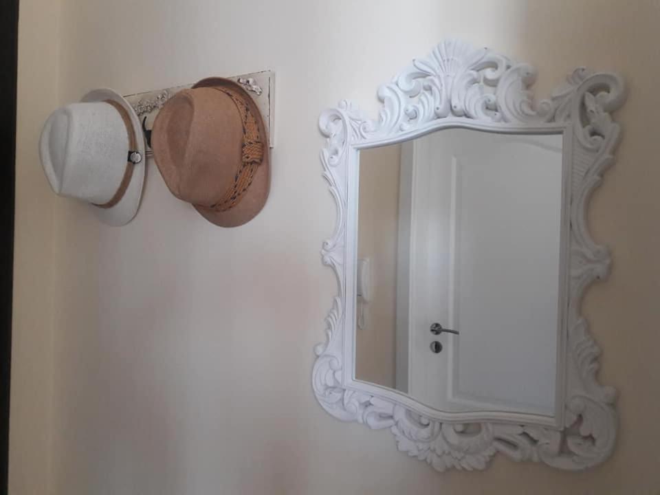 a mirror on a wall with a bucket and a cup at Апартамент Оскар in Burgas City