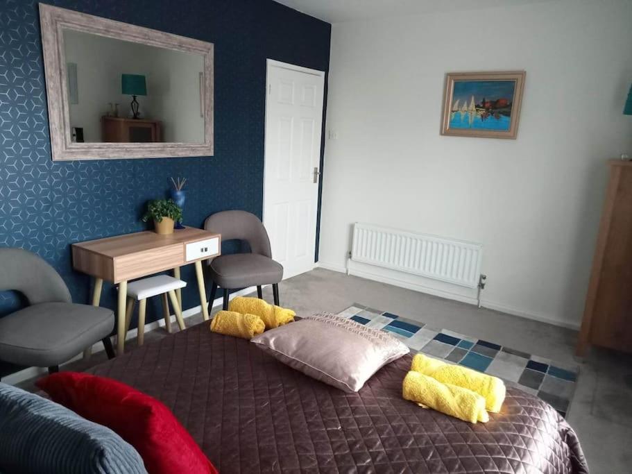 a bedroom with a bed with yellow and red pillows at House with free parking and large garden in Wyke Regis