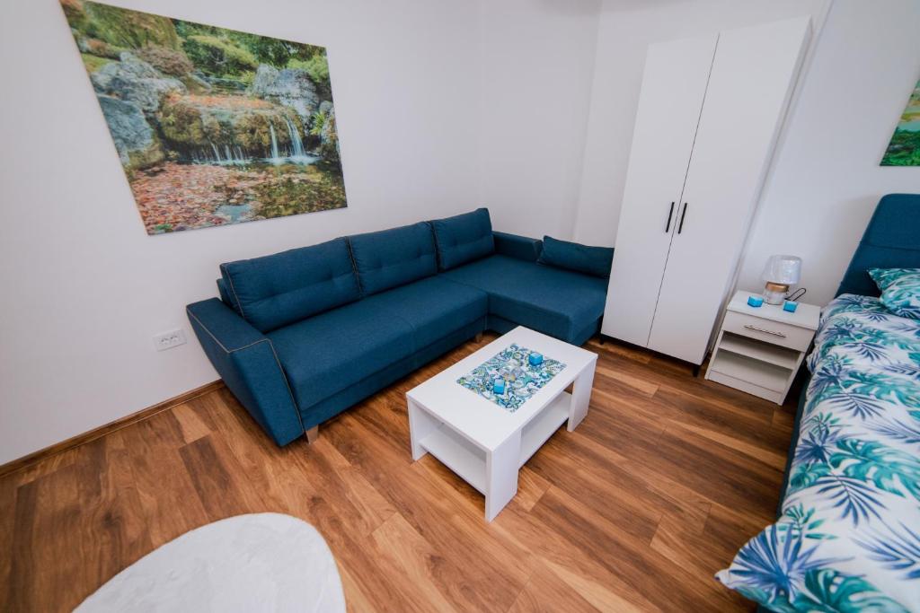 a living room with a blue couch and a table at Apartman Neca Trebinje in Trebinje